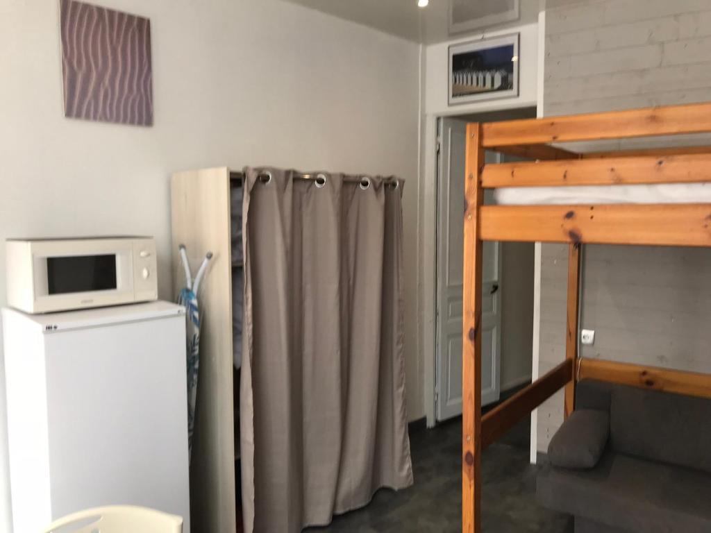 une chambre avec un rideau de douche et un réfrigérateur dans l'établissement Studio 2 proche mer Dunkerque Malo les bains, à Dunkerque