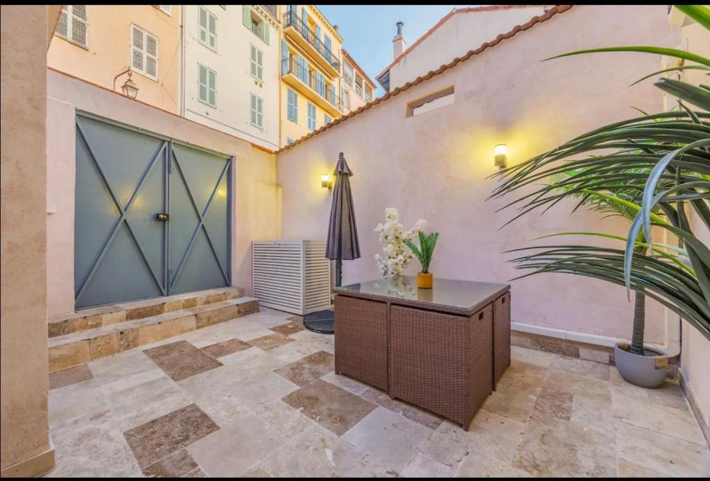 un patio avec une porte, une table et une plante dans l'établissement Suquet Perrissol, à Cannes