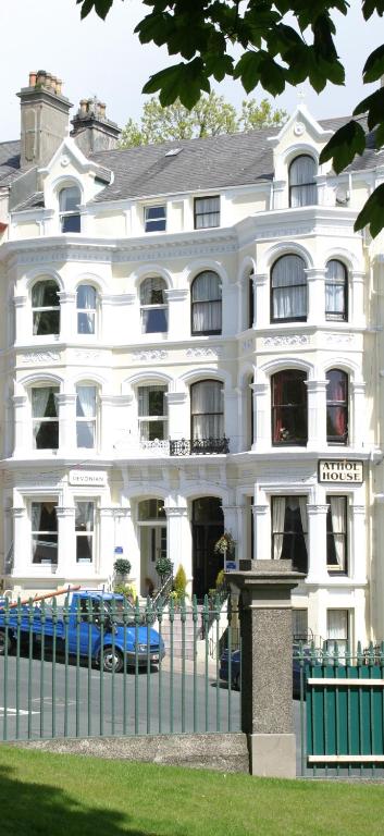 un edificio bianco con una recinzione di fronte di The Devonian a Douglas