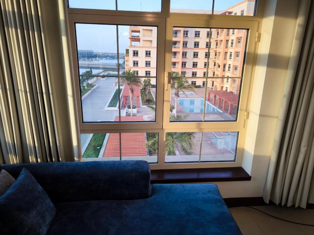ein Wohnzimmer mit Couch und großem Fenster in der Unterkunft هبة مارينا مدينة الملك عبدالله الاقتصادية in King Abdullah Economic City
