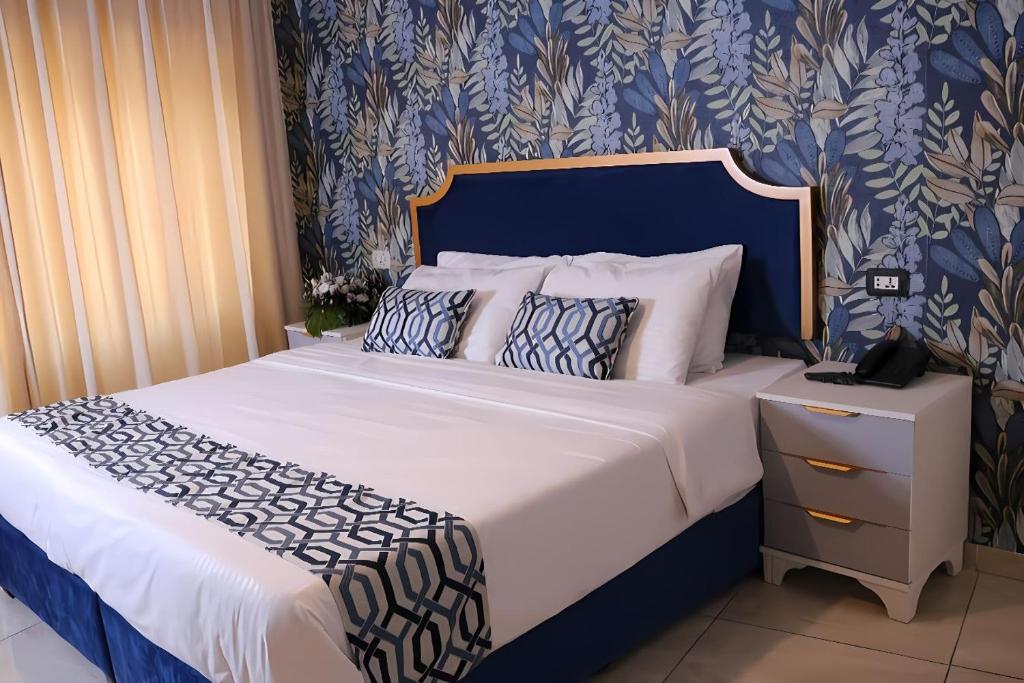 a bedroom with a large bed with blue and white sheets at New Rafi Hotel in Amman