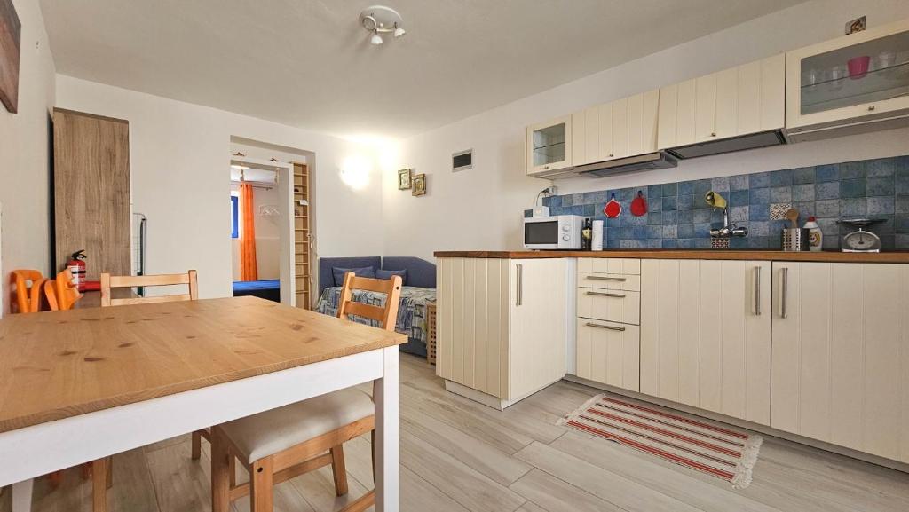 una cucina con mobili bianchi e un tavolo di legno di Blu Violati a Novigrad Istria