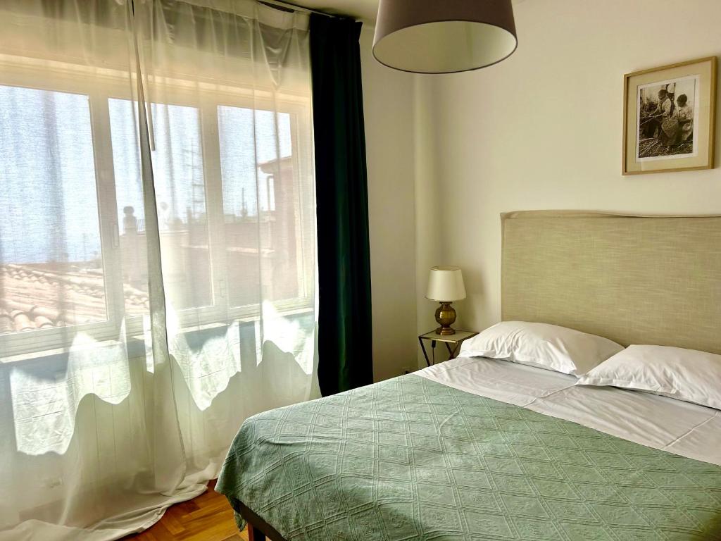 a bedroom with a bed and a large window at Taormina Casa Liliana in Taormina