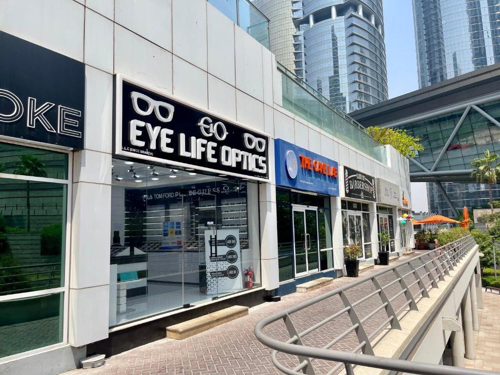 a building with an eye life optic sign in a city at Rustic Elegance By The Lake Studio Cabin In Jlt in Dubai