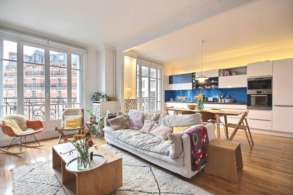 un salon avec un canapé et une table et une cuisine dans l'établissement Gambetta family pad, à Paris