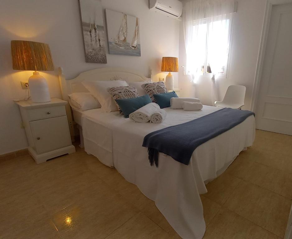 a bedroom with a large white bed and a window at El balcón de Alexia, 5 minutos del aeropuerto in Partida de La Cañada