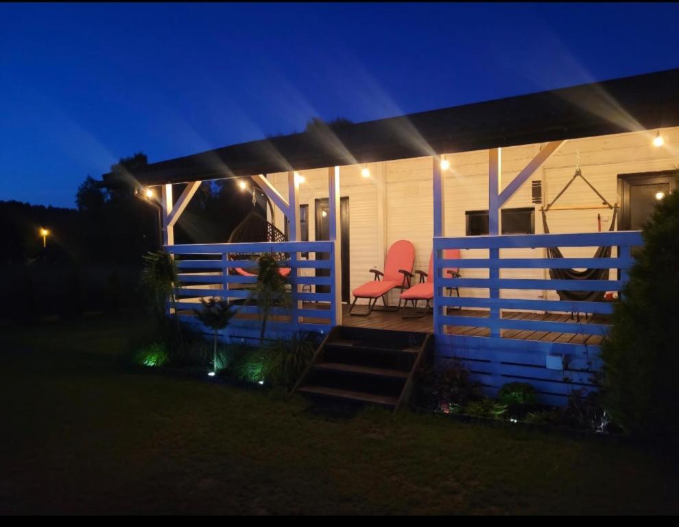 a house with a porch at night with lights at Domek na Roztoczu - Jacuzzi in Krasnobród