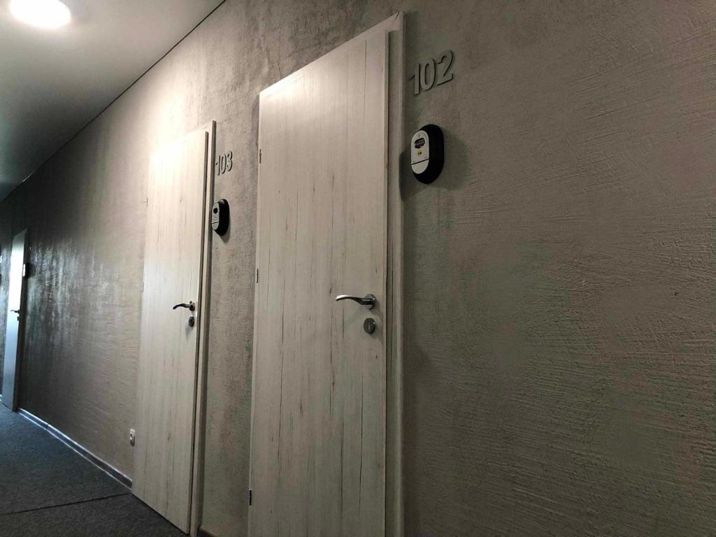 a row of wooden doors in a hallway at Estrella Palanga Home in Palanga