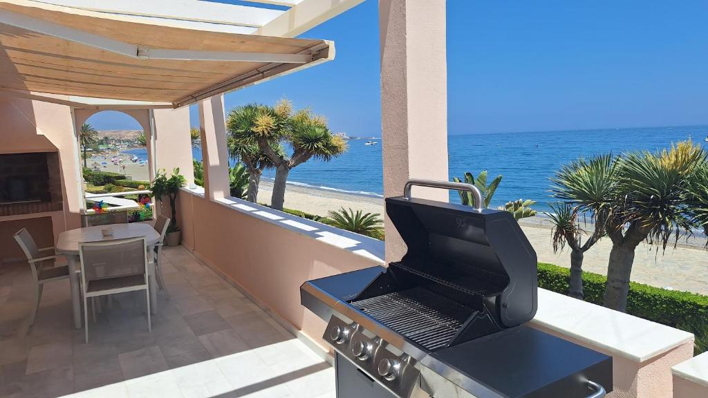 a grill with a laptop on it on a balcony with the beach at Beach View Playa Del Moral in Estepona