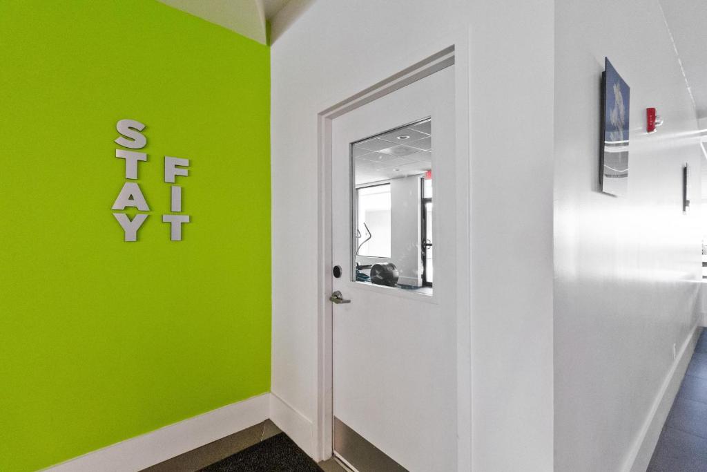 a hallway with a green wall and a door at 11 Condo-Hotel With Double Bed And Community Pool Miles From Disney! in Kissimmee