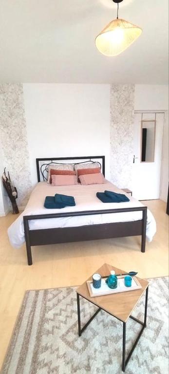 une chambre avec un grand lit et une table dans l'établissement Location chambre spacieuse avec balcon et piscine, à Albi