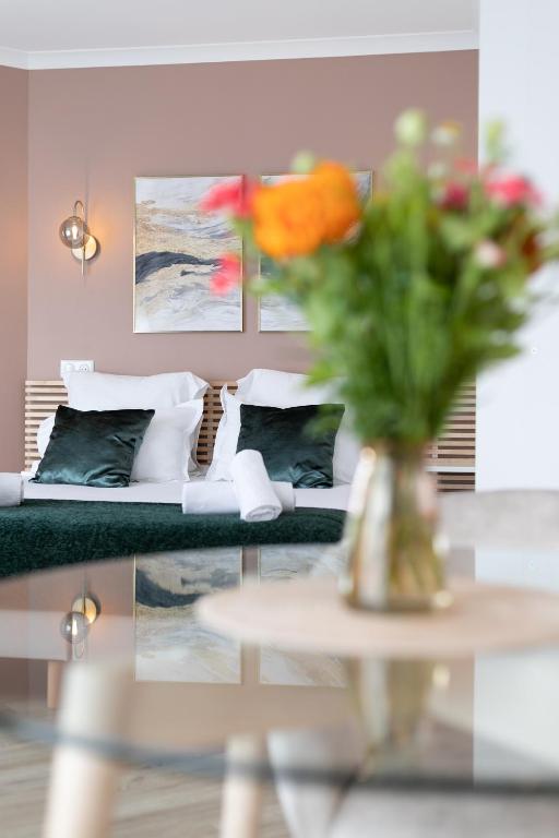 - un salon avec un canapé et un vase de fleurs sur une table dans l'établissement Sweet'Issy - Balcon - Parking - Climatisation - WIFI - MyBestLoc, à Issy-les-Moulineaux