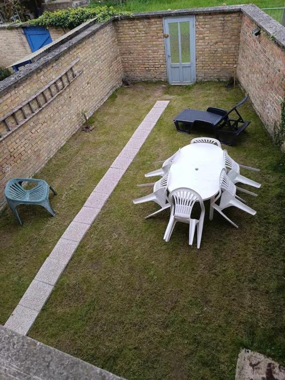 un groupe de tables et de chaises dans une cour dans l'établissement Beau studio à 2mn de la mer et avec jardin, à Bray-Dunes