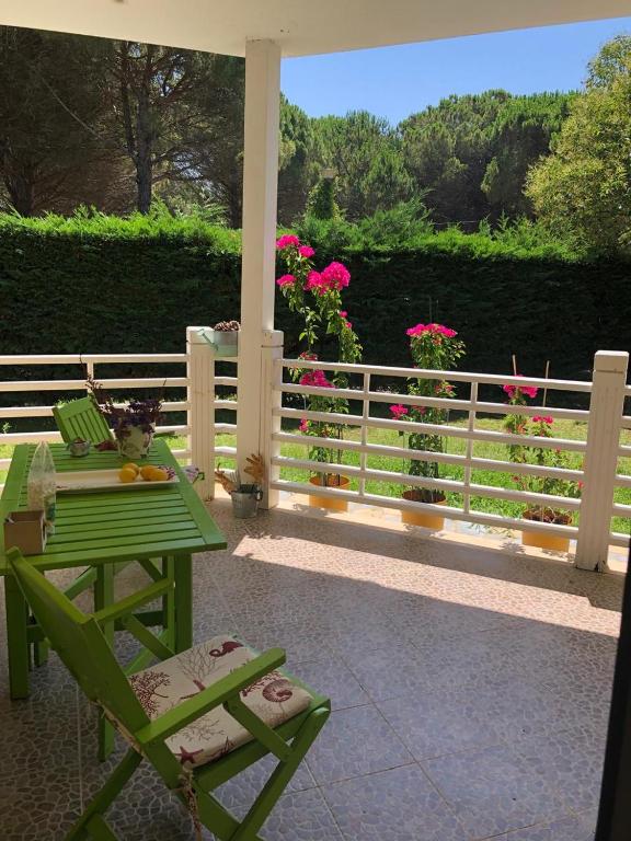 a green table and chairs on a porch with flowers at Pines House in Draç