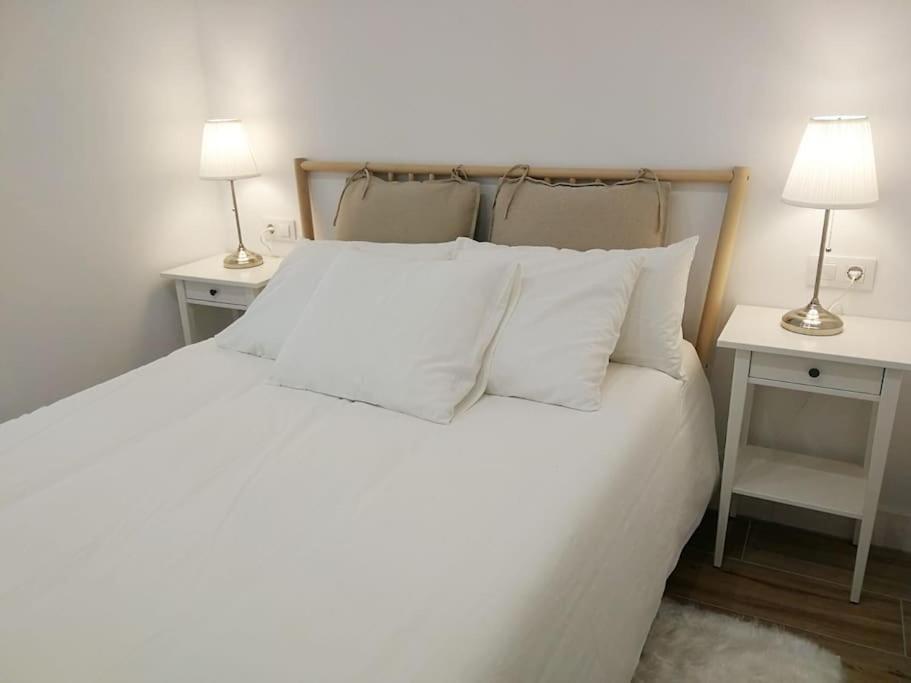 a bedroom with a white bed with two end tables at Habitación Sa Palomera con baño privado a 2 min del mar in Blanes