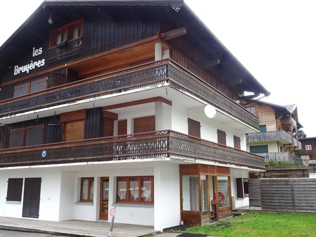 un bâtiment blanc avec un toit noir dans l'établissement Les Gets : Appartement 6 pièces, 13 pers, Wi-Fi, 200m commerces, 450m pistes, draps et serviettes inclus - FR-1-802-55, aux Gets