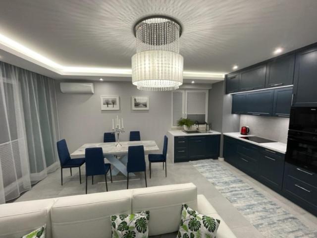 een keuken met een tafel en stoelen en een eetkamer bij AK Apartamenty Centrum in Białystok