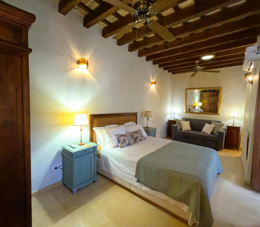 una camera da letto con un letto grande e un divano di Casa de Medina a Medina Sidonia