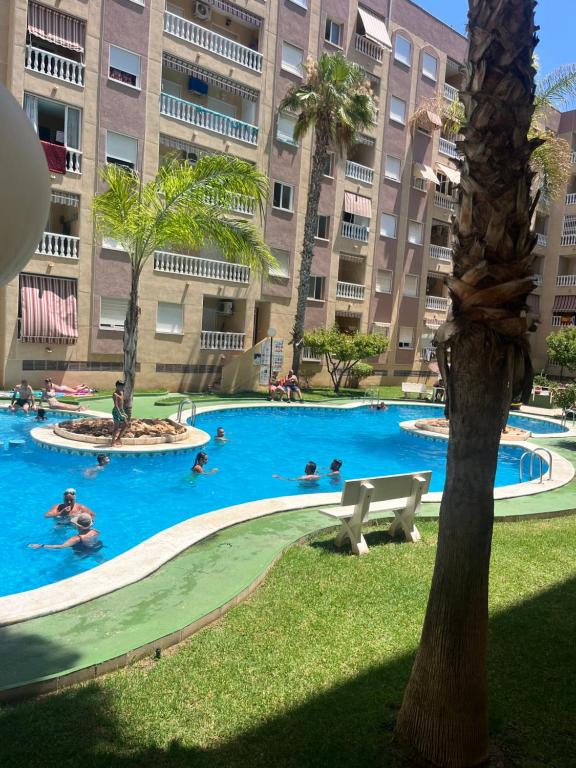 a large swimming pool with people in a large building at Magdalena Apartament in Torrevieja