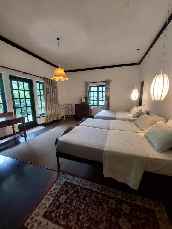 a large bedroom with two beds and a piano at Gartmore Estate Bungalow in Maskeliya
