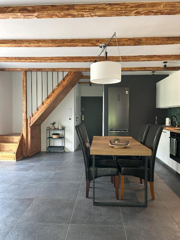 a dining room with a wooden table and black chairs at Dom w lesie in Dzbądzek