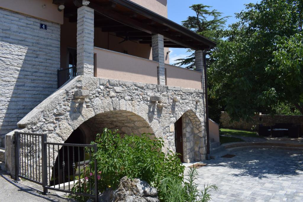 a building with a stone oven in a yard at Apartments Kamelija in Punat