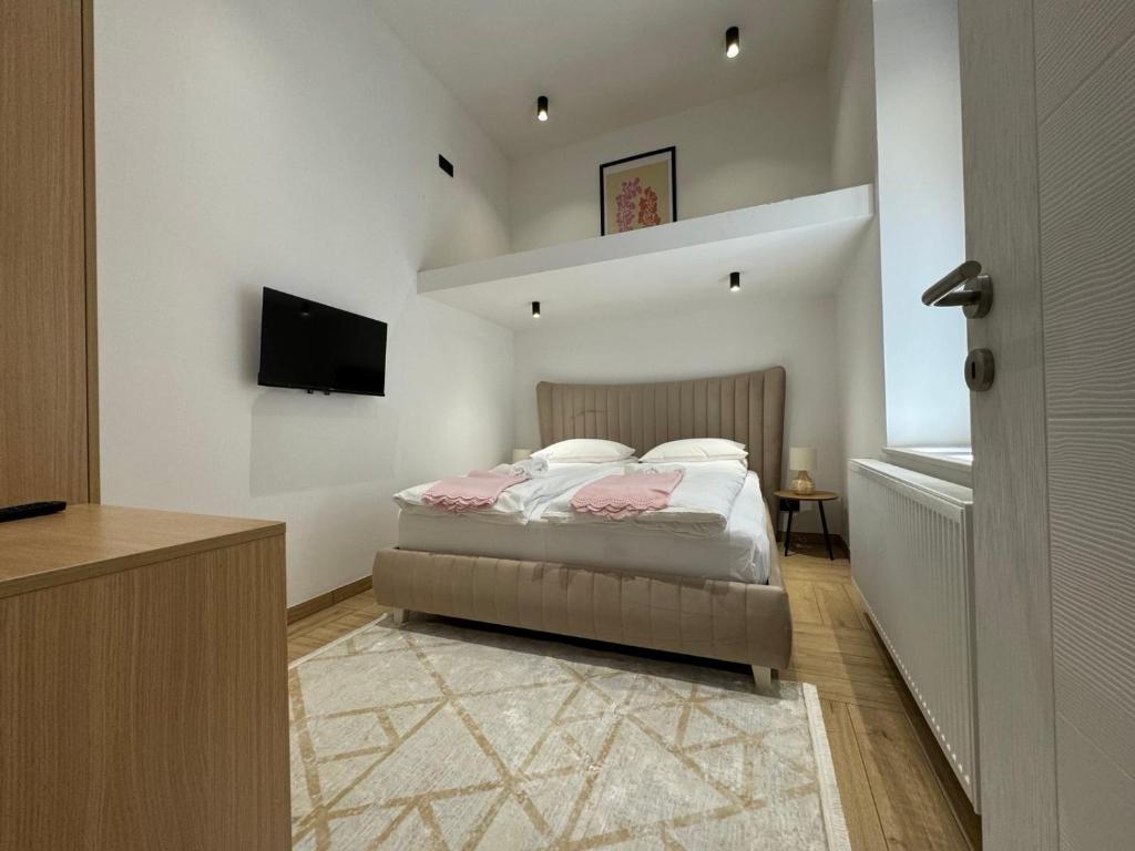 een slaapkamer met een bed en een televisie. bij Apartman A in the heart of Ferhadija - Parking available in Sarajevo