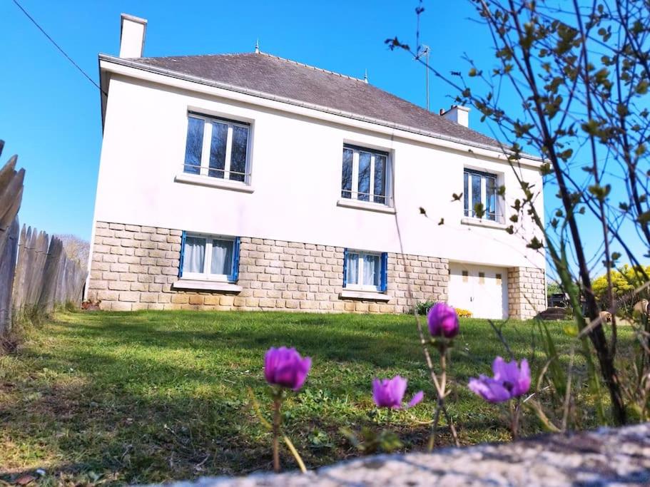 une maison avec des fleurs violettes devant dans l'établissement Chez pépé, à Clohars-Carnoët