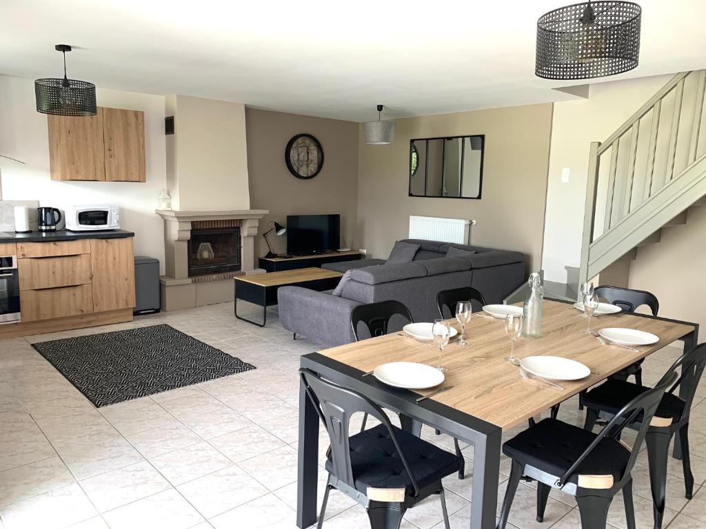 un salon avec une table et un canapé dans l'établissement COTTAGES LA CHENERIE, à Ancteville