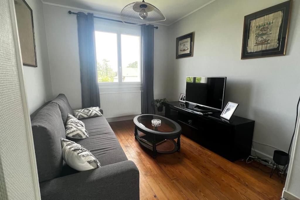 un salon avec un canapé et une télévision dans l'établissement Jolie maison individuelle de Village avec Jardin, à Villeréal