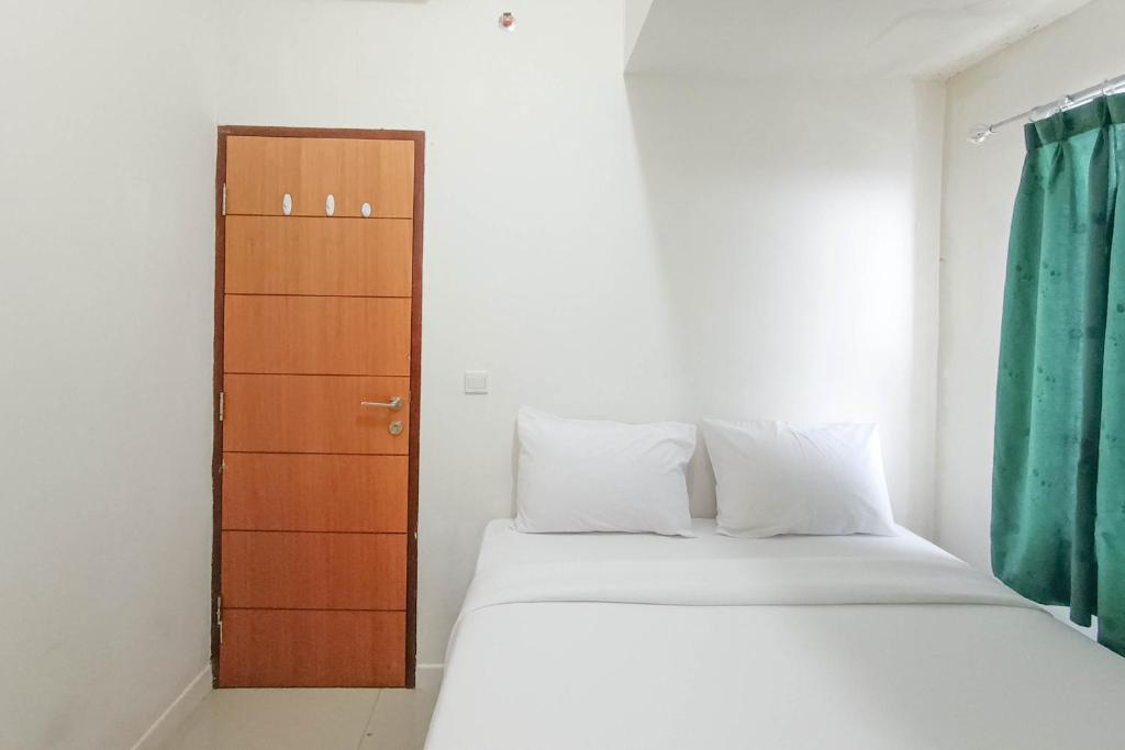 Voodi või voodid majutusasutuse Nice and Homey 2BR at Vida View Makasar Apartment By Travelio toas