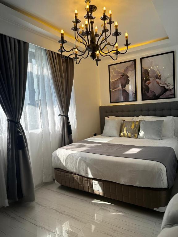 a bedroom with a large bed and a chandelier at MAKATI Isabela Luxury in Manila