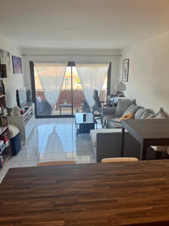 un salon avec un canapé et une table dans l'établissement Agréable appartement climatisé devant la mer avec parking, à Antibes