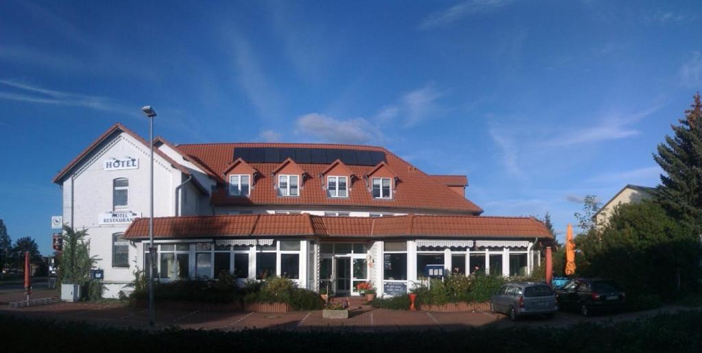 ein großes weißes Gebäude mit rotem Dach in der Unterkunft Hotel Kiebitz an der Ostsee in Börgerende-Rethwisch