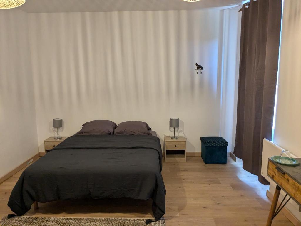 una camera da letto con un letto con due comodini e due lampade di Chez Cornélia a Estaing