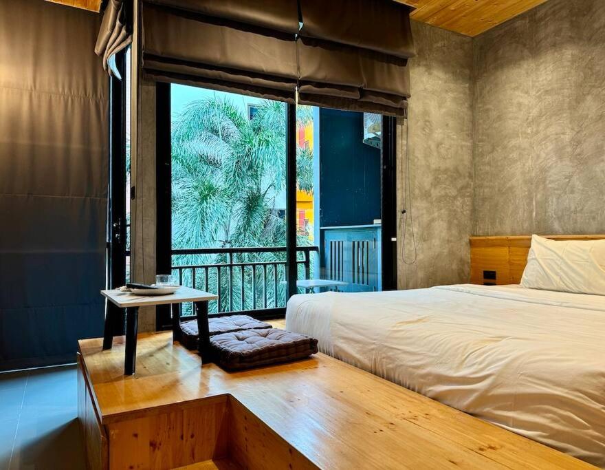 a bedroom with a bed and a large window at Taya NaiHarn, Scenic View, Modern Studio, Relife Windy in Rawai Beach