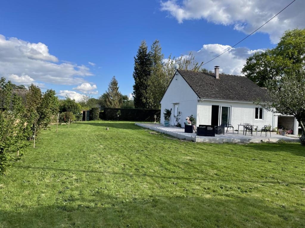 une maison blanche avec une cour dotée d'une pelouse dans l'établissement la mer à la campagne, à Angiens
