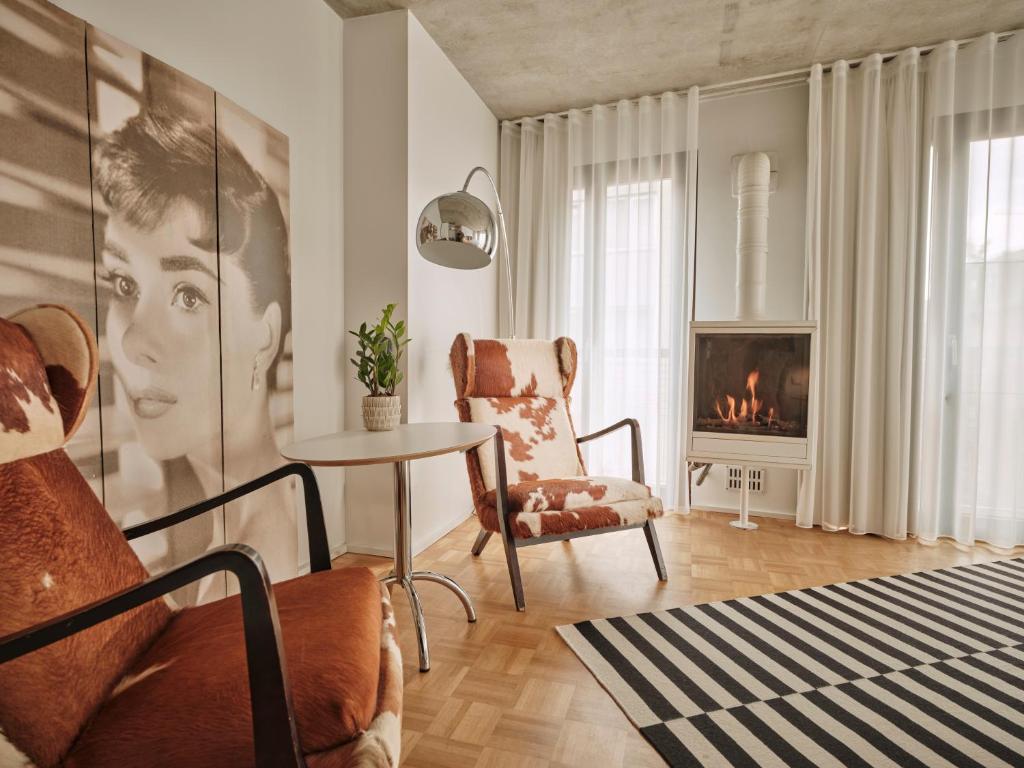 uma sala de estar com uma mesa, uma cadeira e uma lareira em BANKS Antwerp em Antuérpia
