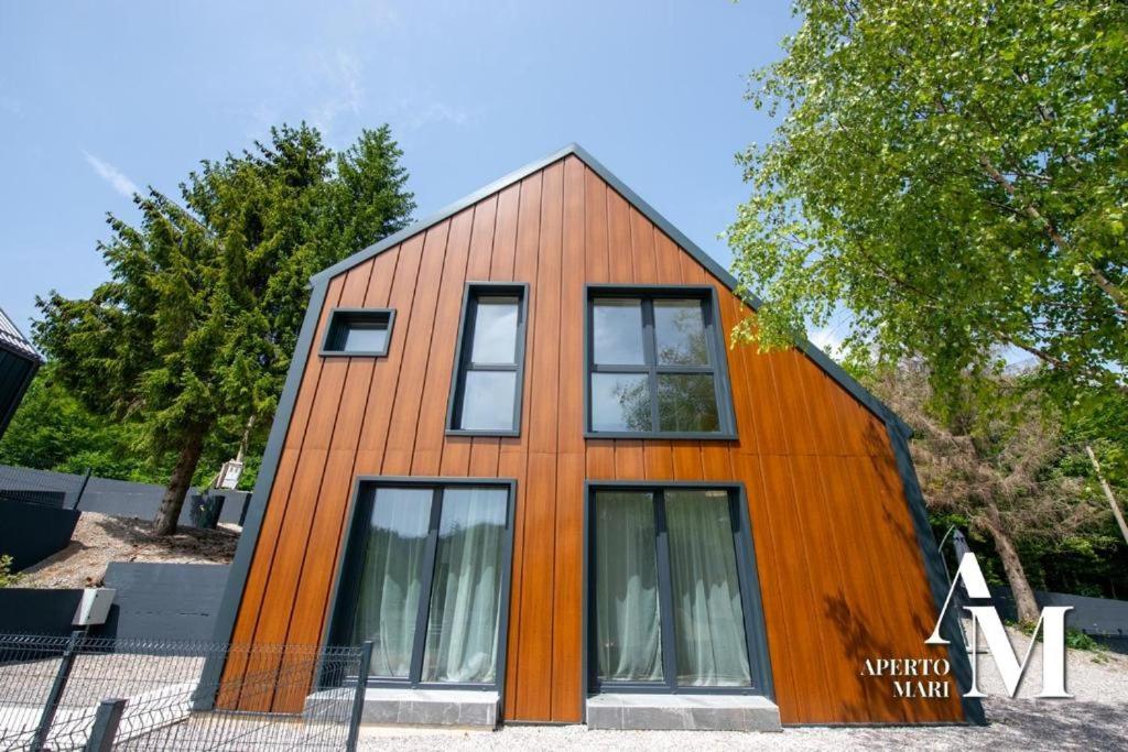 a house clad in wood with windows at Gorska Idila "Smreka" - a Modern House in Quiet Area with Wellness in Stari Laz