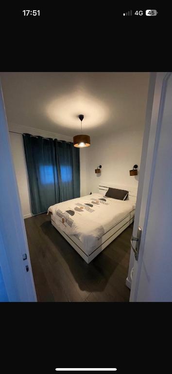 une chambre avec un lit avec une couette blanche dans l'établissement Ayline, à Drancy