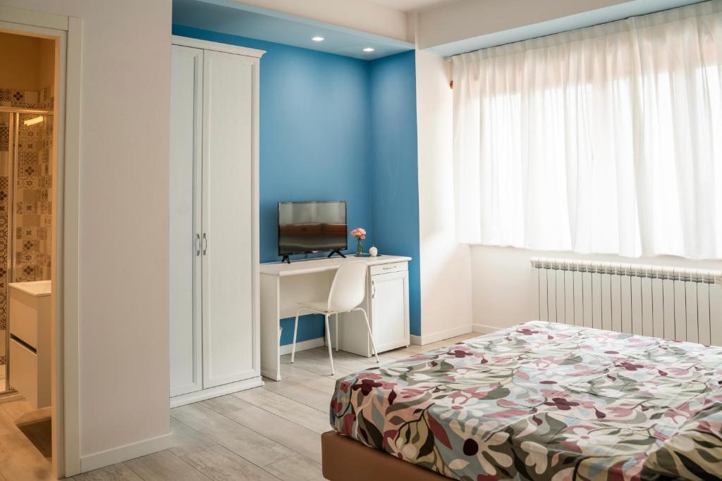 a bedroom with a bed and a desk with a television at Sogna Firenze apartments in Florence