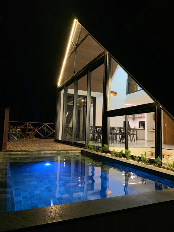 a house with a swimming pool at night at Chalés Piribless-Ikigai in Pirenópolis