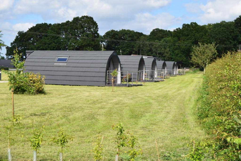 a row of gray barns in a field at Oakwood Escapes in North Cliff