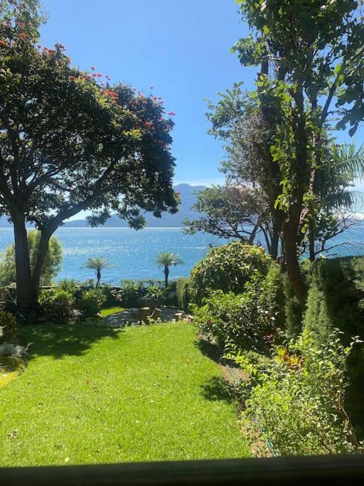 een tuin met bomen en uitzicht op het water bij Peaceful Hideaway in Santa Cruz La Laguna