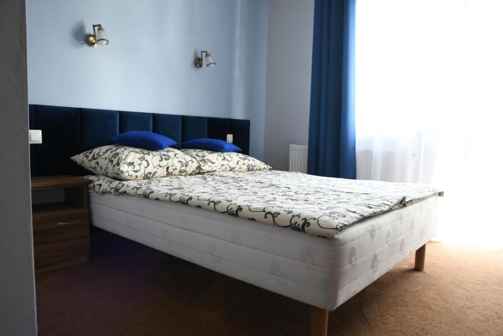 a bedroom with a bed with blue walls and blue pillows at Pokoje gościnne GRYF in Rewal