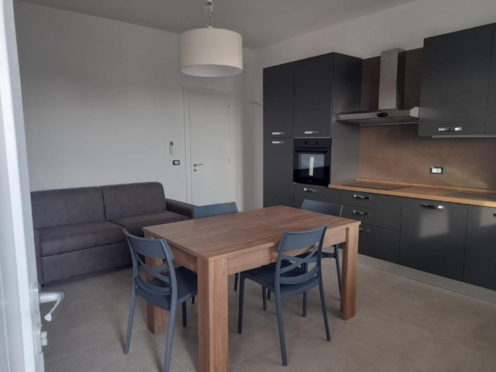 a kitchen and dining room with a wooden table and chairs at Apartment Emanuela in Porto Cesareo