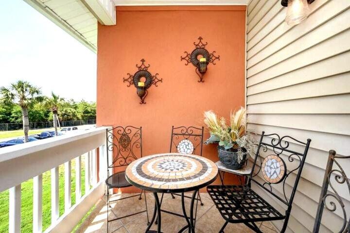 eine Terrasse mit Tisch und Stühlen auf einem Balkon in der Unterkunft Captains Quarters 3 Comm Pools Pet Friendly in Destin