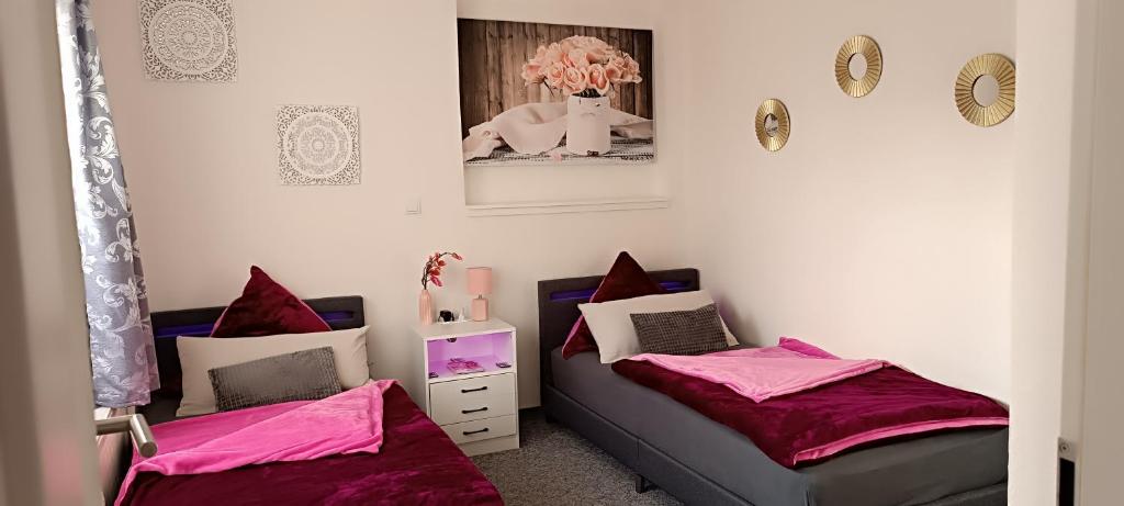 2 Betten in einem Zimmer mit rosa Bettwäsche in der Unterkunft Ferienwohnungen Auetal in Kucksdorf