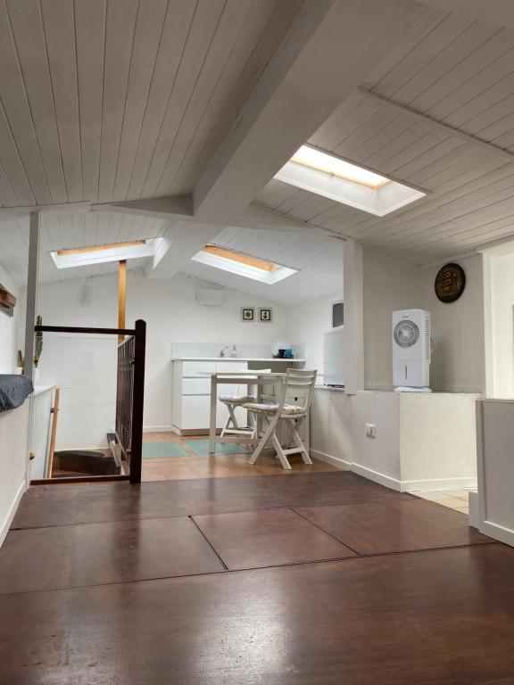 Una habitación grande con una mesa y una cocina. en Delizioso Monolocale mansardato, en Viareggio