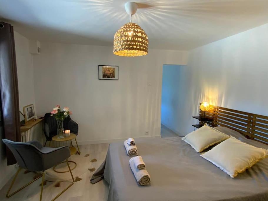une chambre avec un grand lit avec une chaise et un lustre dans l'établissement Maisonnette, à Toulon